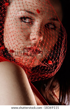 Face shot of fashion model with red mesh over face