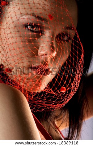 Face shot of fashion model with red mesh over face