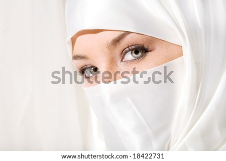 Close up face shot of woman in white face veil