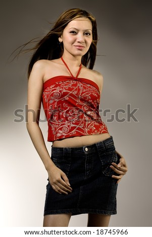 Asian girl in studio with denim skirt and red top