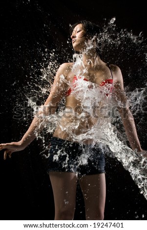 Water splashes over beautiful Asian fashion model