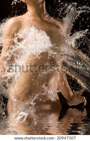 Naked body with water splashing over it