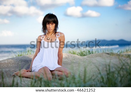 Fashion model on beach in white summer dress