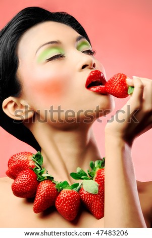 Creative makeup beauty shot of model with strawberries, passion and desire