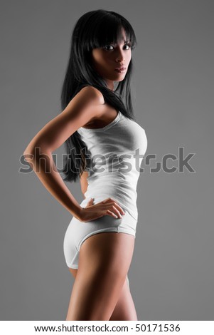 Beautiful Asian woman in slinky dress on grey background