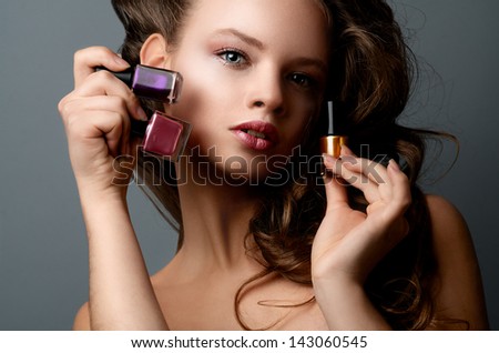 Young girl with nail polish on gray background
