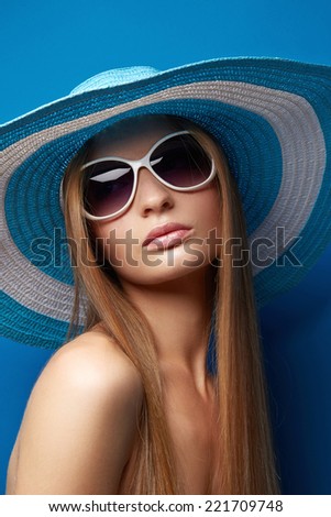 Beautiful Young woman in hat on blue background