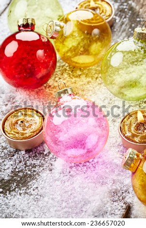 Christmas balls with golden candles on wooden background