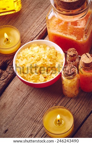 Spa still life with sea salt, oil and scrub for body on wooden background