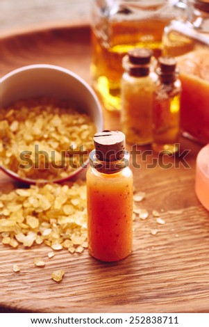 Spa still life with orange scrub for body on wooden background
