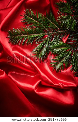 Fir branches on red fabric background
