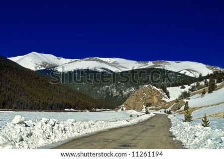 The snow covered Colorado Rocky Mountains with blue sky seem to come to life along Guanella Pass
