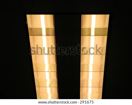 This is a picture of two light fixtures together in a lit room.  The lights make the well lit room apear to be pitch-black