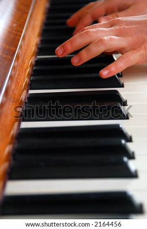 Hands of child practicing piano.  Shallow depth of field.
