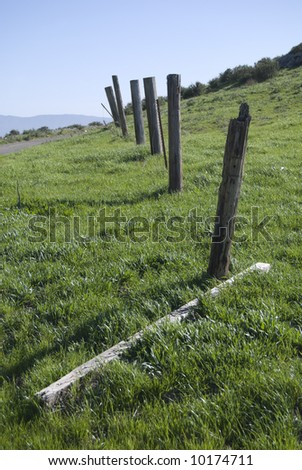 Broken Fence Across Green Field