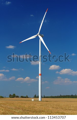 Wind power station with turbine against blue sky