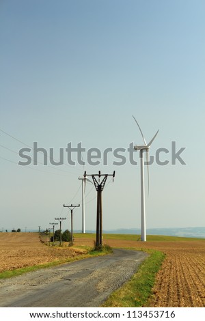 Wind power station and electricity pylons near the road