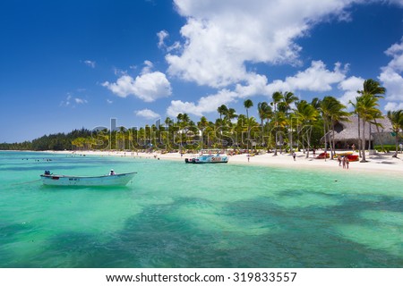 Playa BaÂ¡varo, Dominican Republic- April 19, 2015: Diving boats moored at the beach with palm trees in the high noon