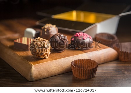 Chocolate handmade candies on a kitchen table. Chocolate box open.