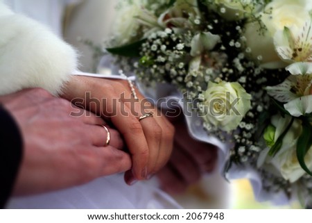 Just married. Hands with rings and wedding bouquet.