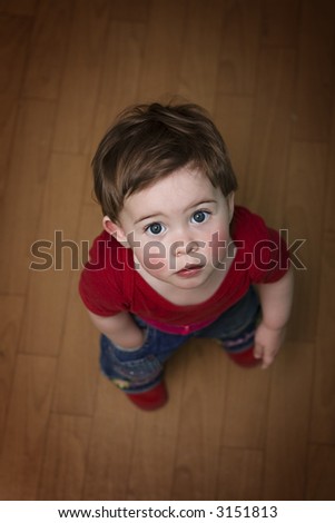 Cute baby standing on her feet, looking up, one hand in pocket. Super cute!