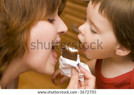 Mother and daughter about to bite a candy bar