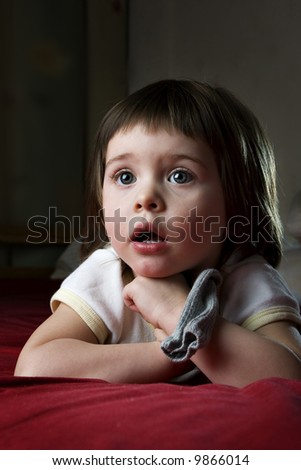 A child totally taken by watching a cartoon on TV