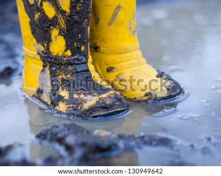 Yellow boots in puddle