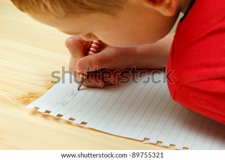 Boy writing letter to Santa at Christmas