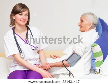 Happy joyful nurse caring for  elderly patients helping their days in nursing home.