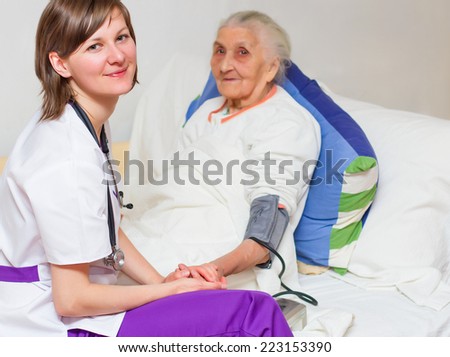 Happy joyful nurse caring for  an elderly woman  helping her days in nursing home.