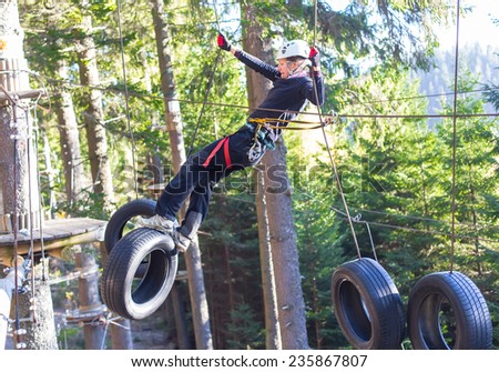 woung woman  hanging on tires in an adventure park in the forest
