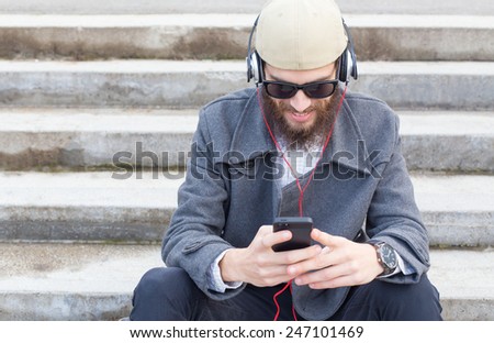 Smiling hipster guy listening to his favourit music.