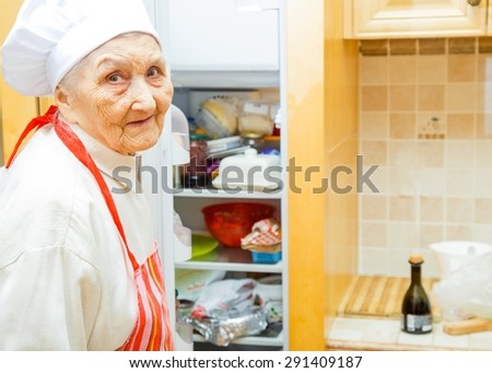 Elderly lady in the kitchen at home preparing to cook.