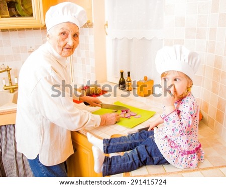 Grandmother cooking together with grand-daughter in the kitchen.