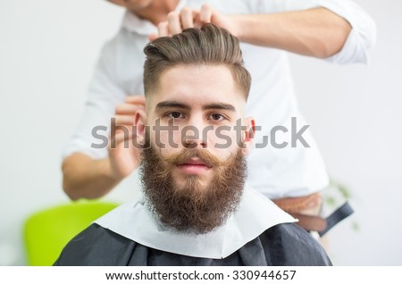 Hipster guy getting ready for the shooting at the barber.