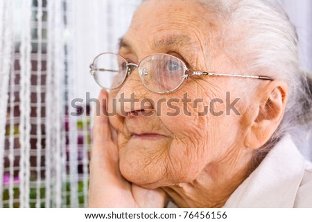 Old woman at the window, dreaming the past