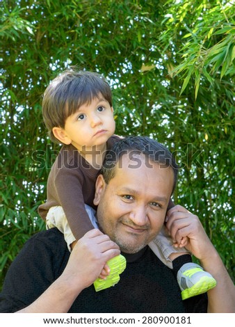 Hsipanic father gives multiracial son ride on shoulders