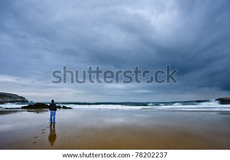Young man in beach and storm