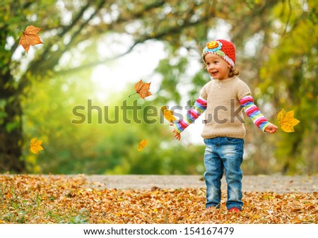 Cute Child Playing With Autumn Leaves