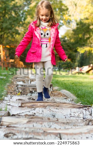 Five year old girl walking over pebbles. Sensory Discovery Walk. Sensory garden.