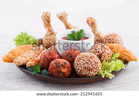 Various fried chicken appetizers with tomato dip