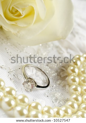 Nice wedding background wedding dress fabric with pearls,engagement ring and a rose