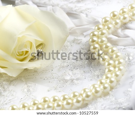 nice wedding background wedding dress fabric with pearls, ring and a rose