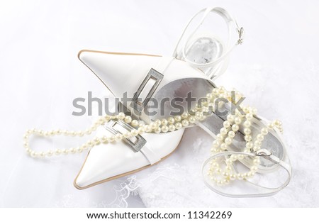 white decorated shoes and pearls on the wedding dress