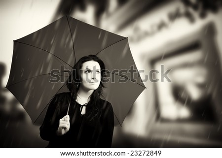 Beautiful young woman with umbrella on rainy day