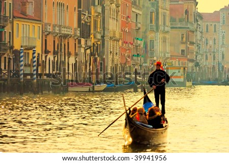 Gondolier navigates the venetian canal in sunset light
