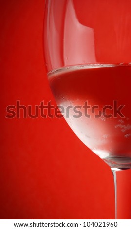 red drink in the wine glass on red background