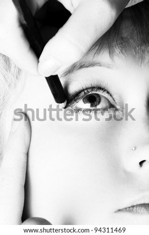woman doing eyes treatments.toned and high key picture