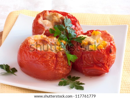 stuffed tomatoes with cheese, corn and mince on white plate